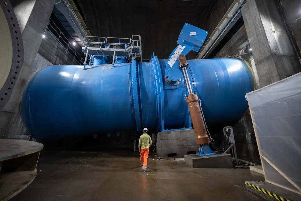 Funcionário caminha em direção a uma das válvulas de segurança gigantes do conduto forçado, em Nant de Drance, oeste da Suíça. — Foto: Fabrice COFFRINI / AFP