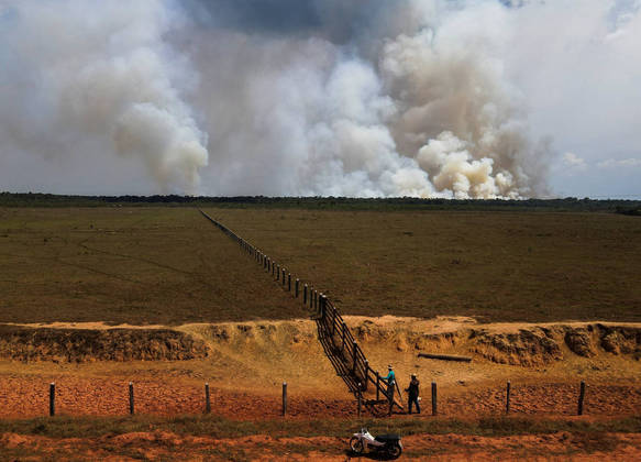 Farmers are seen as smoke from burning vegetation rises in Brazilian Amazon rainforest near the Transamazonica national highway, in Humaita, Amazonas state, Brazil, September 8, 2021. Picture taken September 8, 2021 with a drone. REUTERS/Bruno Kelly
