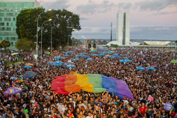 Pessoas manifestam em rua com bandeira LGBT